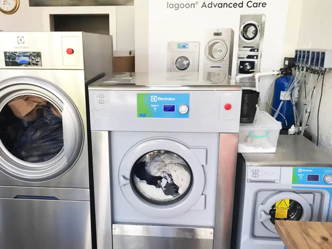 Commercial laundry equipment in a clean workspace. Commercial laundry equipment in a clean workspace.