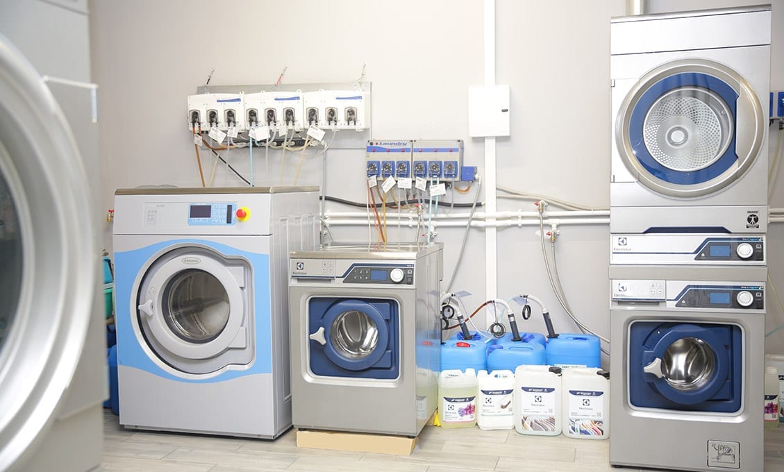 Compact commercial laundry equipment arrangement. Compact commercial laundry equipment arrangement.