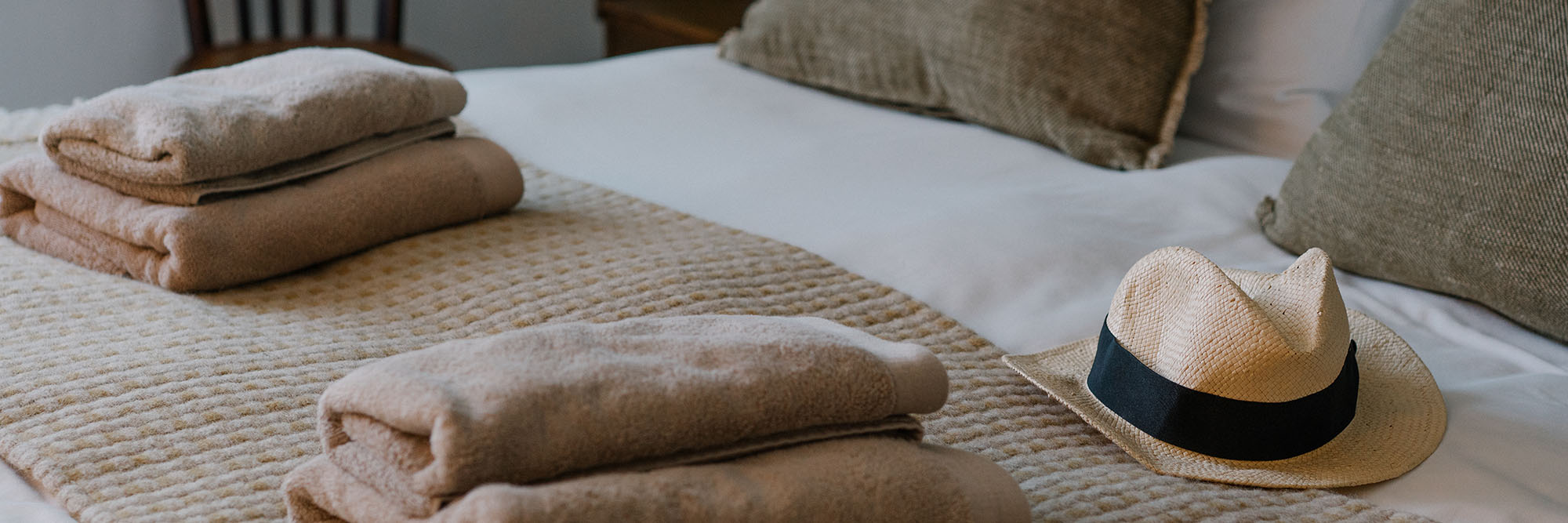 Bett mit Hantüchern und Hut