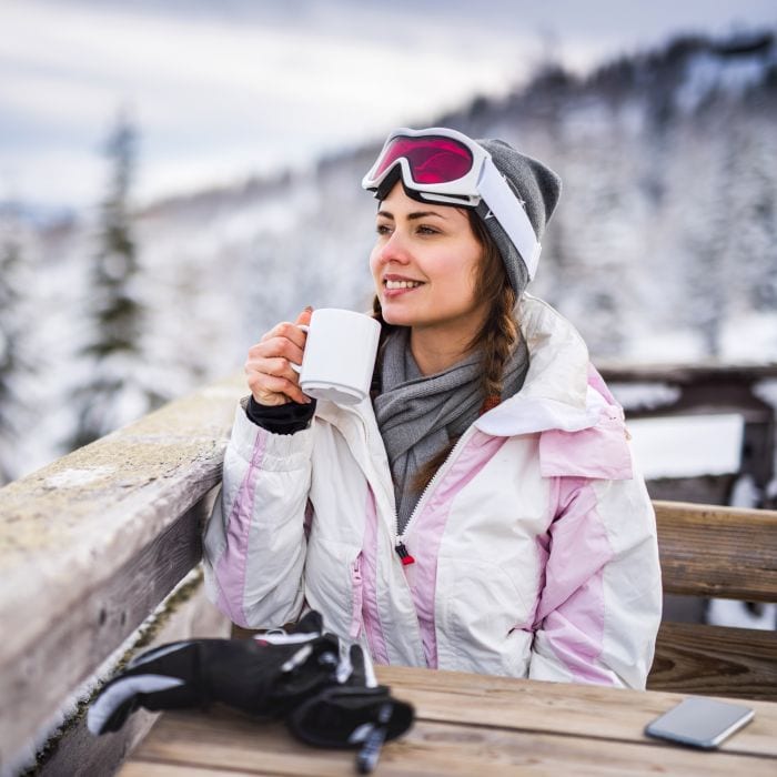 young-woman-in-a-cafe-at-ski-resort-700x700