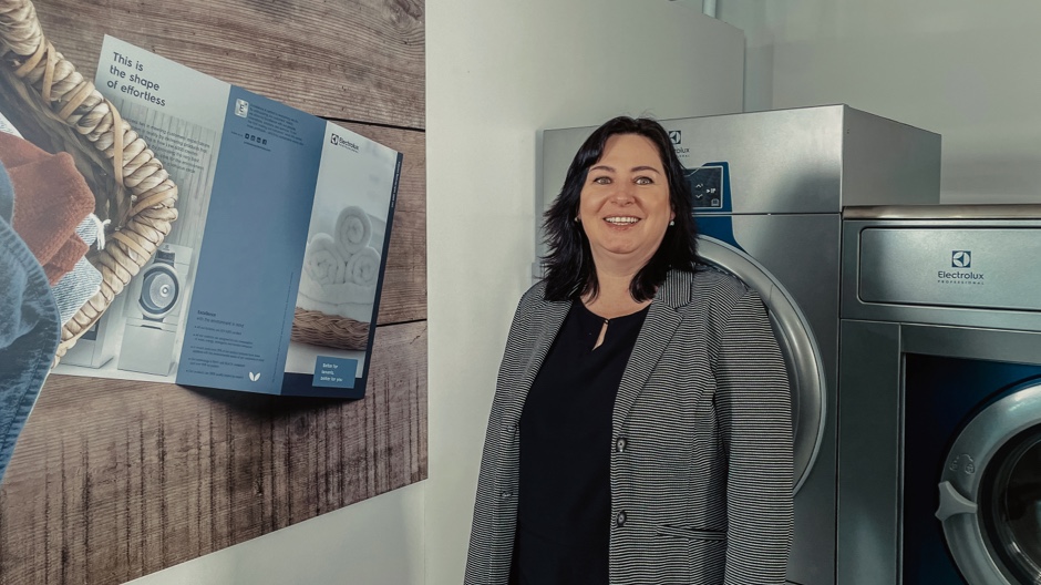 Woman standing beside Commercial Washer and Dryer. Woman standing beside Commercial Washer and Dryer.