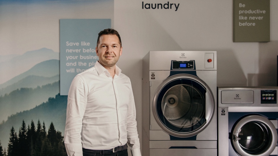 Businessman showcasing Commercial Washer and Dryer units Businessman showcasing Commercial Washer and Dryer units