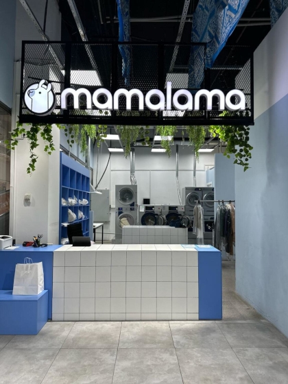 Front view of Mamalama laundry facility featuring brand signage and Electrolux Professional laundry equipment in a modern setting